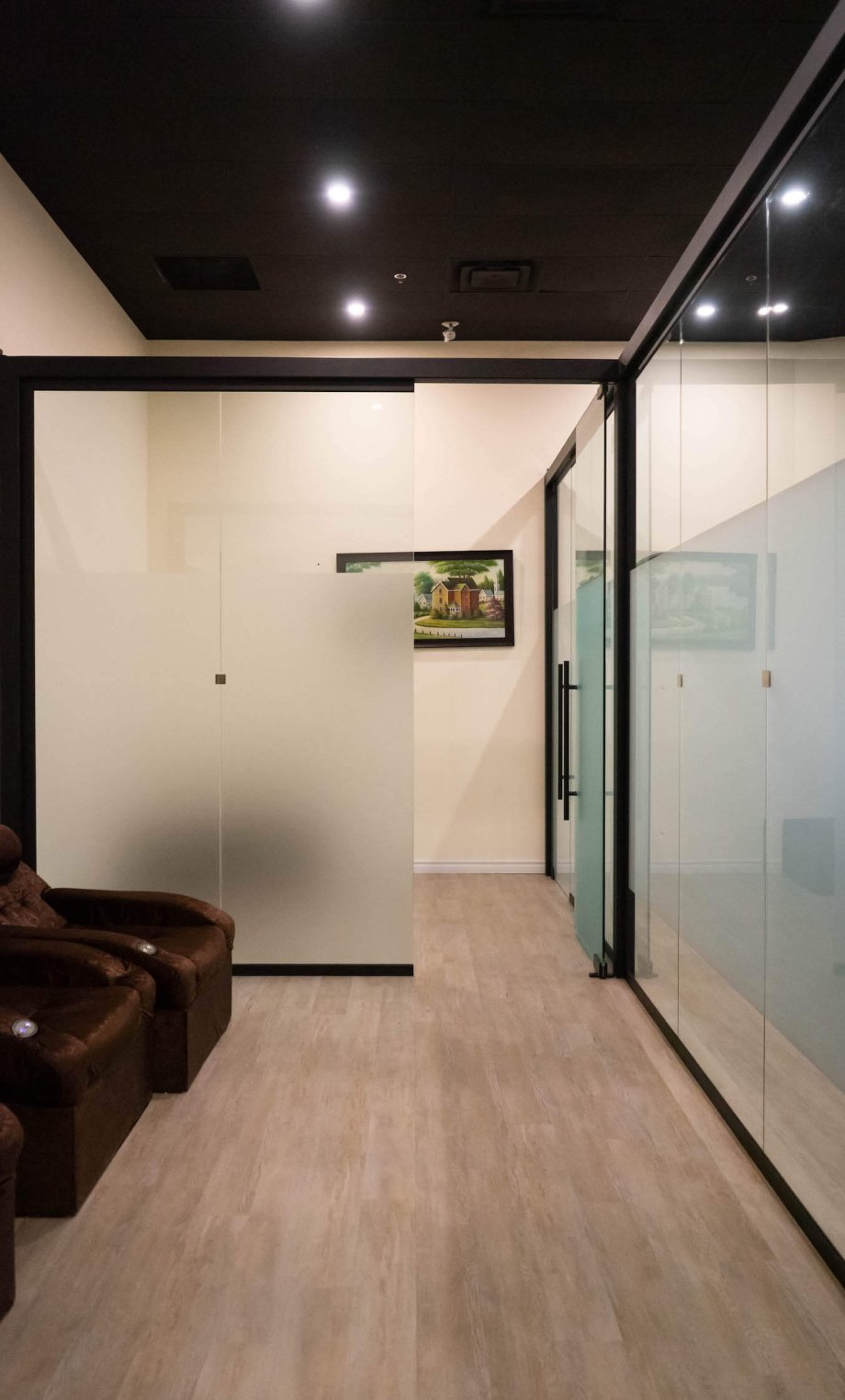 Office Glass Partitions With Frosted Glass And Black Frame To Divide The Waiting Room With Armchairs